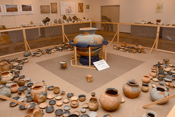 展示室の様子。中央に甕が置かれ、周囲にはたくさんの土器がサークル状に並んでいます。