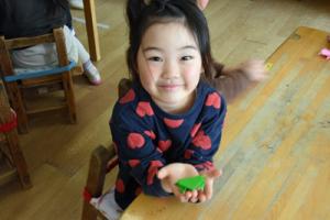 できたカエルの折り紙を見せている園児