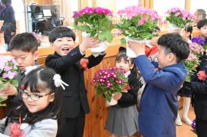 友達と花を嬉しそうに上げている写真