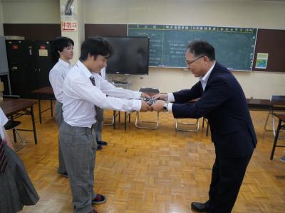 ポロシャツを受け取る荒井副会長