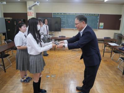 ポロシャツを受け取る生徒会役員